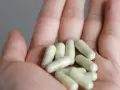 Kilka kapsułek z witaminą K2 w dłoni. Pamiętaj o odpowiednim witamina k2 dawkowanie dla zdrowia kości i serca.
