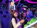 Kinder mit Kronen auf dem Kopf spielen in einer Spielhalle in Berlin Rennspiele.