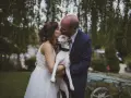 Un couple s'embrasse tendrement, tenant leur chien, dans cette photo de mariage.