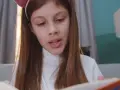 Urocze dziecko z książką, zanurzone w lekturze, z uszkami na głowie.