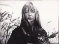 Irena Szczurowska w otoczeniu trzcin, zamyślona, z kosmykami włosów opadającymi na twarz.