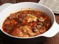 Conejo en cazuela con zanahorias y champiñones en salsa roja.