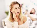 Kobieta z odrętwiałą twarzą po wizycie u dentysty.