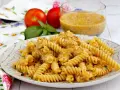 Fusilli conditi con una cremosa salsa di ricotta e pomodorini, guarniti con basilico fresco.