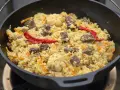 Herzhaftes Plov-Rezept im Kessel: Reis, Fleisch, Karotten, Knoblauch und scharfe Chilis. Ein Festmahl!