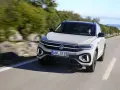 Jasnoszary Volkswagen T-Roc jedzie po krętej drodze. Nawet przy potencjalnych usterkach, ten model prezentuje się dynamicznie.