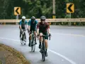 Cyclists on a wet road, navigating curves, embodying the stress recovery adaptation cycle.