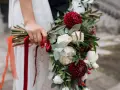 Elegancki bukiet z czerwonych i białych kwiatów, ozdobiony wstążkami, idealny jako kwiaty na ślub w prezencie.