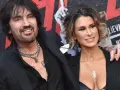 Tommy Lee i jego żona, Brittany Furlan, uśmiechają się do aparatu na czerwonym dywanie.
