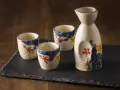 Zestaw do sake z ceramicznym dzbankiem i trzema kieliszkami, ozdobiony motywem kwiatowym. Idealny do degustacji sake, niezależnie od tego, sake ile procent ma zawartości alkoholu.