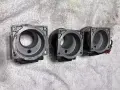 Trzy metalowe korpusy przepływomierza leżą obok siebie na białym, fakturowanym tle.