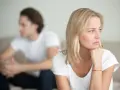 Ein Paar sitzt getrennt auf einem Sofa. Die Frau denkt nach, während der Mann abgewandt sitzt. Trennungsunterhalt steuerlich absetzbar ist ein wichtiges Thema.