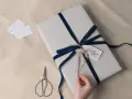 Prezent na 8 rocznicę ślubu, owinięty w szary papier i ozdobiony granatową aksamitną wstążką. Drobna gałązka i karteczka "To my love" dodają uroku.