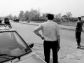 Policjanci na gierkówce kontrolują ruch. Jeden z nich stoi przy radiowozie, drugi kieruje ruchem.