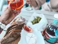 Aperitif co to? Kieliszek Pamplelle Ruby Rose, bagietka, ser brie i winogrona tworzą idealny zestaw na letnie popołudnie.