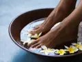 Relaxing foot bath with frangipani flowers. The amount of epsom salt in a foot bath can vary, but a common recommendation is 1/2 cup per gallon of water for a soothing soak.
