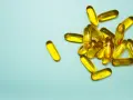 En hög med genomskinliga, gulaktiga kapslar som innehåller alla vitaminer.