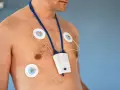 Mężczyzna z elektrodami EKG na klatce piersiowej i urządzeniem do badania holtera. Unikaj wysiłku fizycznego podczas badania holtera.