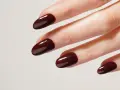 Mani curate con unghie laccate di un intenso color **baby boomer marrone**, lucide e perfette.