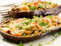 Berenjenas rellenas de carne picada, gratinadas con queso y perejil fresco. Un plato casero y delicioso.