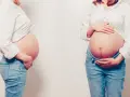 Dwa brzuchy w ciąży, jeden z profilu, drugi z przodu, oba w dżinsach i białej koszuli.