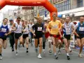 Löpare i en maratonlopp, många med nummerbrickor. En kvinna springer i mitten.