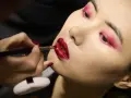 Labbra rosse intense e un trucco audace sugli occhi creano un look da sirena.