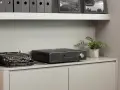 Czarny wzmacniacz zintegrowany Roksan K3 stoi obok zabytkowej maszyny do pisania.