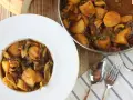 Plato de papas con choco y guisantes en salsa. Un delicioso guiso casero listo para servir.