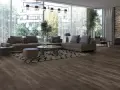Ciemne panele podłogowe świetnie komponują się z szarą sofą i dywanem. Idealne do wnętrz, do czego dobierać kolor paneli, by stworzyć przytulną atmosferę.
