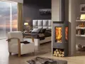 Acogedora habitación con cama, sillón y estufas esquineras modernas que irradian calor.