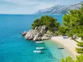 Majowa pogoda w Chorwacji zachwyca. Spokojne morze, piaszczysta plaża i góry w tle tworzą idealny krajobraz.