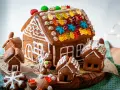 Kreative Ideen für ein Lebkuchenhaus: Ein detailreiches Lebkuchenhaus mit bunten Gummibärchen und kleinen Lebkuchenhäusern drumherum.