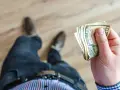 Dług w prowidencie, jak śmierć, nieuchronnie zbliża się do człowieka, który trzyma w dłoni banknoty.