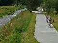 Rowerzyści cieszą się malowniczymi trasami rowerowymi w Muszynie, jadąc wzdłuż rzeki.