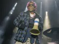 A$AP Rocky na koncercie w kręconych włosach i kratowanej koszuli, trzymający megafon.