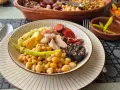 Plato de cocido con garbanzos, patatas, chorizo, morcilla y pimientos.