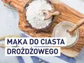 Mąka do ciasta drożdżowego: biała mąka w drewnianej misce i zakwas w słoiku, gotowe do pieczenia.