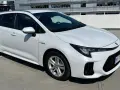 Biały Suzuki Swace Hybrid na parkingu. Elegancki kombi z nowoczesnym designem, gotowy na każdą podróż.
