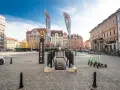Wejście do podziemi z napisem "Movie Gate Wrocław" na placu w otoczeniu zabytkowych kamienic.