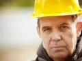 Mężczyzna w żółtym kasku, przygotowujący dokumentację ZUS wykaz stanowisk pracy w szczególnych warunkach.