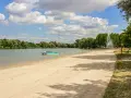 Sommerliche Idylle am Baggersee: Sandstrand, Tretboote und eine Fontäne laden zum Entspannen ein. Hier lässt sich das Leben in Karlsruhe genießen.