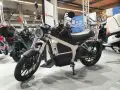 Elegancki motocykl elektryczny Horwin CR6, idealny do zdobycia prawa jazdy na motocykl. W tle inne skutery elektryczne.