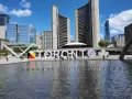 Toronto co zobaczyć: wielki napis TORONTO przed ratuszem miejskim, z fontanną i nowoczesnymi budynkami w tle.