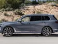 Szary BMW X9 na tle pustynnego krajobrazu. Elegancki SUV z chromowanymi detalami i masywnymi felgami.