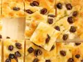 Goldbraune Focaccia mit Oliven, perfekt nach dem original focaccia rezept. Ein Stück ist leicht angehoben.