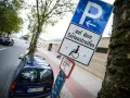 Schild für Behindertenparkplatz auf dem Seitenstreifen. Falschparken wird mit einer hohen Strafe geahndet.