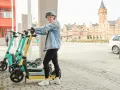 Tjej med hjälm redo att köra elsparkcykel. Tänk på elsparkcykel regler för en trygg resa.