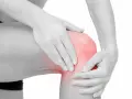 En person håller om ett knä som lyser rött, vilket indikerar smärta. Här sitter benhinnorna, som kan drabbas av inflammation.