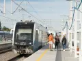 Pociąg na stacji z pasażerami czekającymi na peronie.